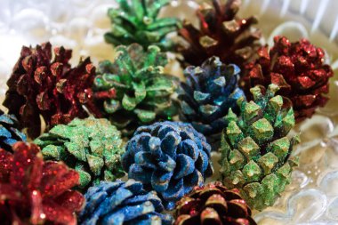 Renkli Noel ağacı konilerinin arka planı. Pullu ağaçtan bir sürü koni. Şenlik arka planı. İyi yeni yıl ruhu. Noel nakış işi.