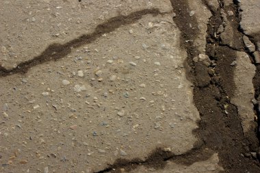 Çatlak gri eski asfalt. Tasarım için sanayi arkaplanı.