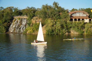 Yat ve tekne manastır adasında bir şelalenin yanından geçiyor.                  