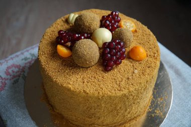 Masanın üzerinde mantarlar ve nar tezgahlarıyla süslenmiş lezzetli ballı pasta.