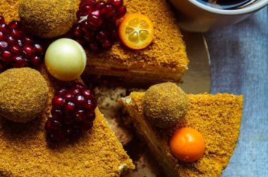 Masanın üzerinde mantarlar ve nar tezgahlarıyla süslenmiş lezzetli ballı pasta.