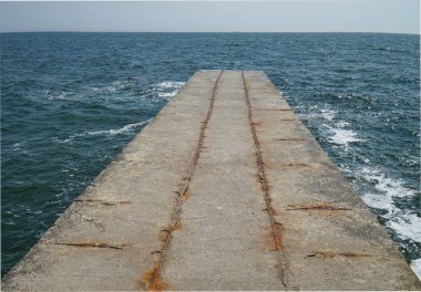 Fırtınalı denizde boş bir iskele belirdi.