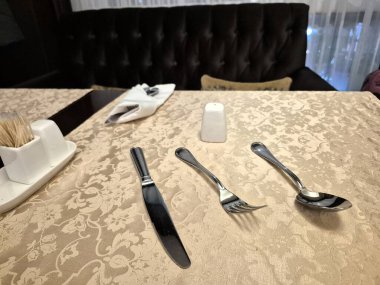 Restorandaki bir masada çatal bıçak ve baharatlar.