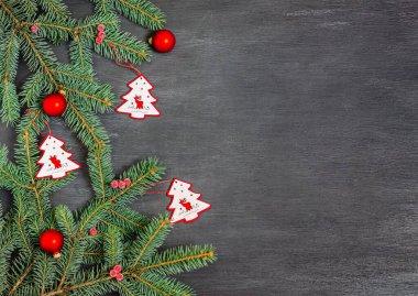 Noel ağacı şeklinde tahta oyuncaklar, kırmızı toplar ve siyah arka planda köknar dalları. Banner, kartpostal için form hazırla. Uzayı kopyala, düz yat. Yeni yıl, Noel, 2021. Üst görünüm.