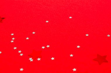 Kırmızı arka planda takılar için dekoratif yıldızlar. Pankart, kartpostal formu. Uzayı kopyala, düz yat. Yeni yıl, Noel, 2021. Yakın plan.