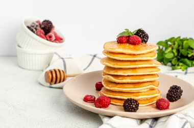 Taze ahududu, böğürtlen, bal ve nane yapraklı ev yapımı klasik Amerikan krepleri..