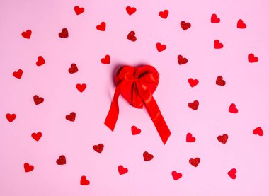 Kurdeleli kırmızı hediye kutusu ve pembe arka planda bir kupa deseni. Aşk konsepti, kopyalama alanı, düz yatış, metin, pankart, üst görünüm.