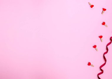 Sevgililer günü için kırmızı kalpli dekoratif mandallar pembe arka planda. Aşk konsepti, kopyalama alanı, düz yatış, metin, pankart, üst görünüm.