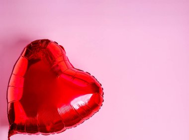 Pembe arka planda kırmızı kalp balonu. Aşk konsepti, kopyalama alanı, düz yatış, metin, pankart, üst görünüm.