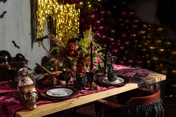 Tavolo di Halloween decorato con alcuni ornamenti spaventosi, come un teschio, un pipistrello nero o una zucca intagliata. Decorazione Halloween Still Life. Decorazioni natalizie — Foto Stock