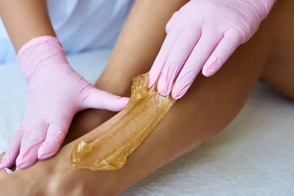 Cosmetologist está aplicando a pasta do epilation. O procedimento de remoção de cabelo — Fotografia de Stock