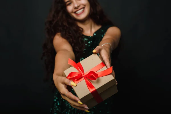 Sexta-feira negra. Uma jovem tem um presente de Ano Novo ou Natal ou Dia dos Namorados em suas mãos em um fundo preto no estúdio — Fotografia de Stock