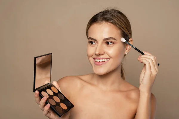 Mujer que aplica maquillaje en los ojos con cepillo cosmético. Concepto de belleza, cosmética y gente — Foto de Stock