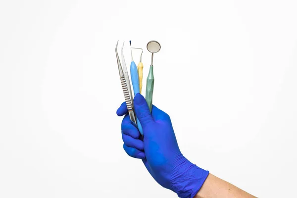 I dentisti mano in un guanto blu tiene strumenti dentali. Pubblicità di servizi odontoiatrici e odontoiatrici — Foto Stock
