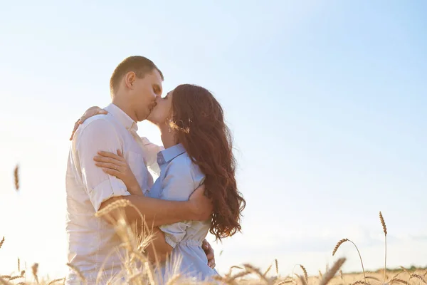 Junges Paar umarmt sich im Weizenfeld, küsst sich und genießt das Leben. Das Konzept der Liebe und korrekte, nicht missbräuchliche Beziehungen — Stockfoto
