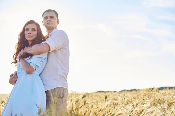 Un jeune couple s'étreint dans un champ de blé, rit et profite de la vie. Le concept d'amour et de corriger les relations non-abusives — Photo