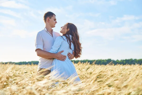 Impressionnant couple heureux s'amuser dans un fond de champ coucher de soleil. Style de vie et concept de voyage — Photo