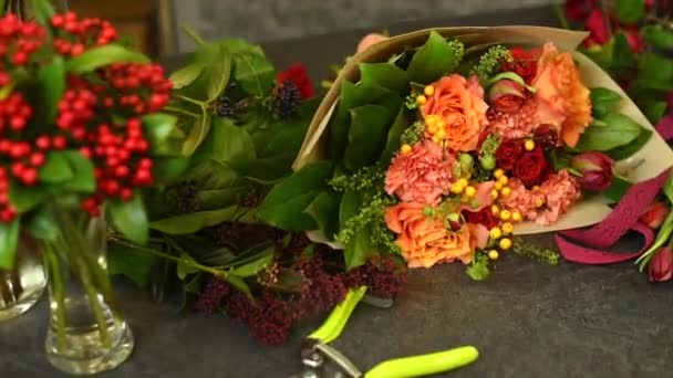 Bloemist werkplek. Een boeket prachtige bloemen ligt op tafel in een bloemenwinkel — Stockvideo