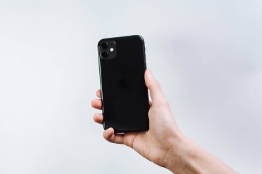 Samara Rusya - 04.05.2020: Akıllı telefonu elinde tutan genç bir adam. iPhone 11 'in arkası, 2 kamera. Müşteri iPhone 11 'i elinde siyah olarak tutuyor.