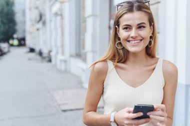 Gülümseyen kadın telefonuyla iletişim kuruyor. kız aletinden e-öğreniyor.