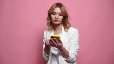 Genç kızıl saçlı kadın cep telefonu kullanıyor SMS yazıyor ya da sosyal medya yayını aşırıyor