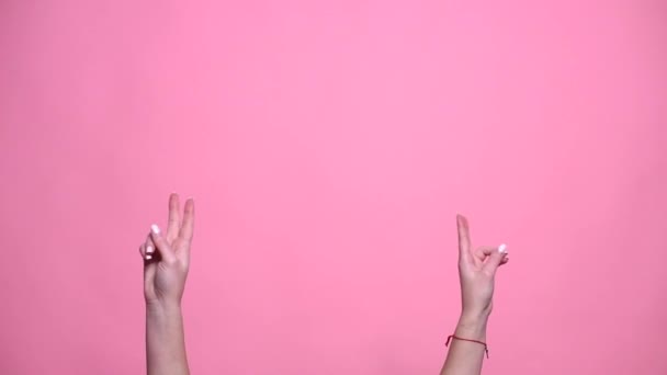 Dua tangan menunjukkan tanda perdamaian dan kemenangan di latar belakang merah muda — Stok Video