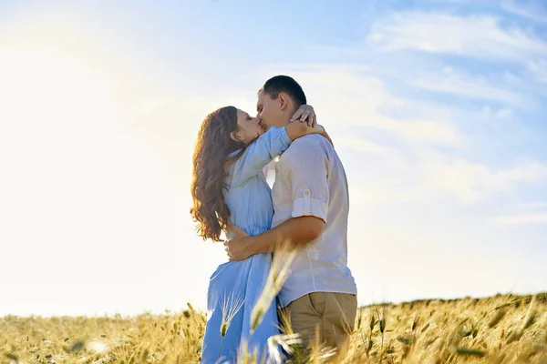 Stilvolles und modernes Paar, das sich in einem Weizenfeld küsst. Eine junge Frau umarmt ihren Freund und küsst sich. Das Konzept von Leidenschaft und Liebe — Stockfoto