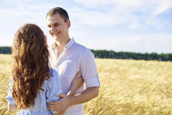 Un couple souriant et heureux. beau mec caucasien portant chemise blanche câlins doux une fille souriante avec des cheveux blonds en robe. — Photo