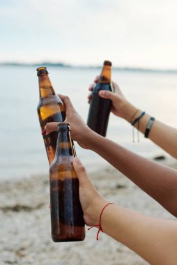 Kumsalda bira içen bir grup arkadaş. Arkadaş Grubu Yaz Sahil Partisi Veriyor