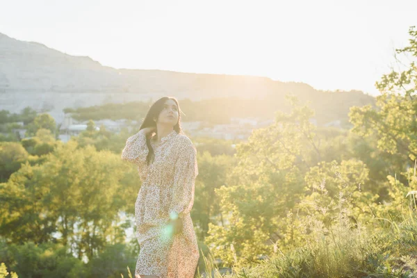 The woman is looking into the distance on the hill. The brunette is in the sunlight — Stock Photo, Image