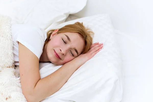O femeie fericită doarme dimineaţa în patul ei. Somn sănătos — Fotografie, imagine de stoc