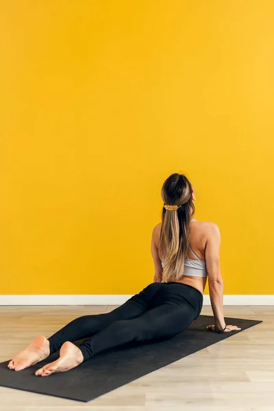 Fitness kvinna meditera medan poserar kobra i gymmet och utövar yoga. Hälsa och avkoppling koncept — Stockfoto