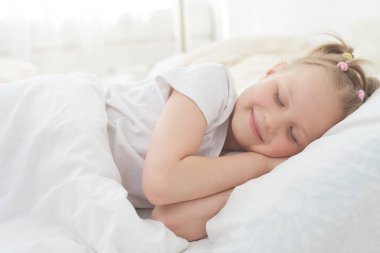 Küçük kız sabahları uyumaktan zevk alır ve uyanmaz. Sabahın erken saatlerinde, güneşin ilk ışıkları