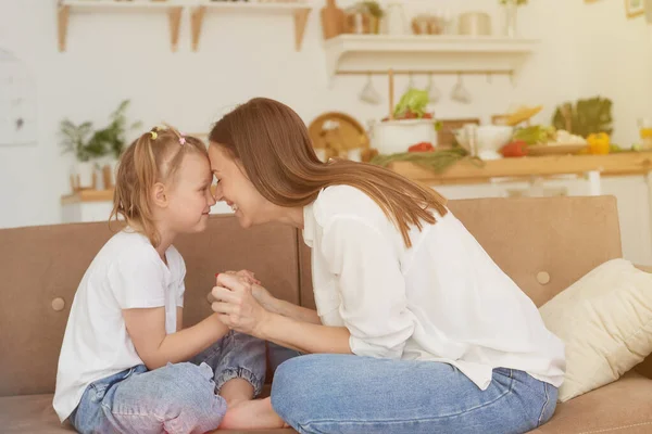 The trusting relationship of mom and daughter. Conversation of a woman with a little girl at home on the couch in the kitchen. Best friends happy motherhood weekend together with kid concept — Stock Photo, Image