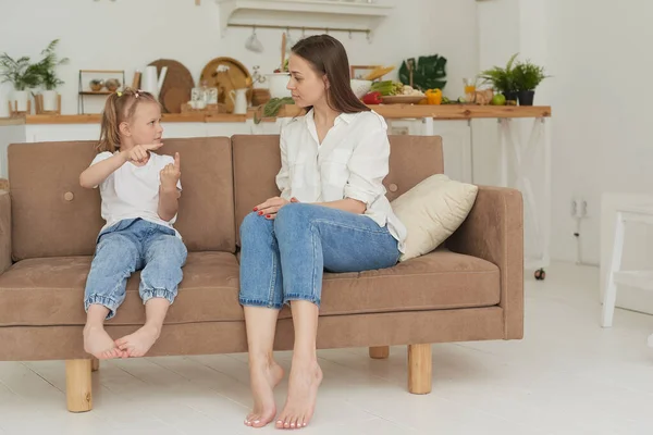 Genç bir anne çocuğuyla kalp kalbe konuşuyor. Psikolog evde küçük bir kızla iletişim kuruyor.