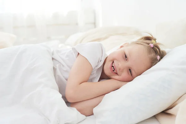 O fetiță se trezește dimineața și zâmbește. Bun vis. — Fotografie, imagine de stoc