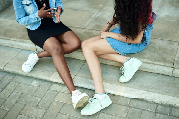 Nogi dwóch młodych kobiet. Rozmowa dziewczyn na ulicy, koncepcja. Bez twarzy. — Zdjęcie stockowe
