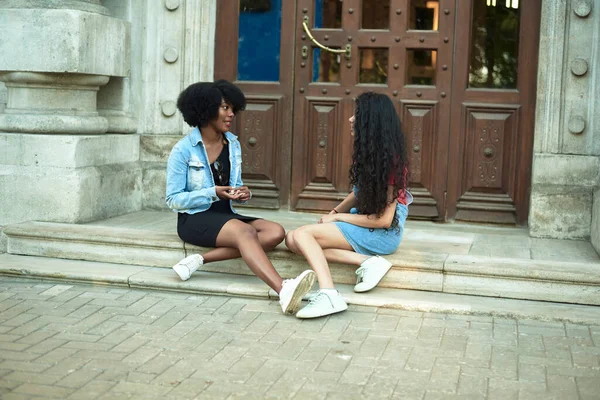 Jovem mulher americana africana feliz sorrindo desfrutar de conversa divertida com amigo indiano, mestiço adolescente conversa rindo conceito ao ar livre — Fotografia de Stock