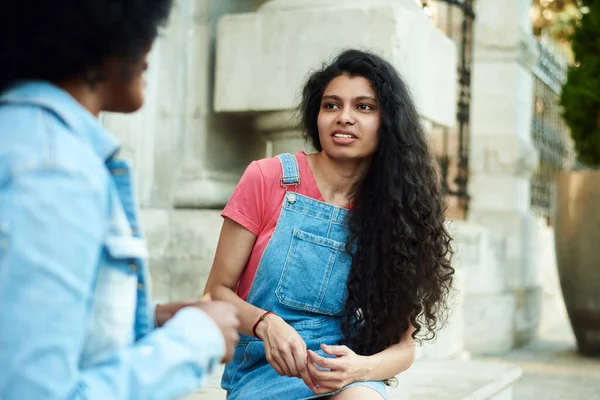 Boldog fiatal afro-amerikai nő mosolyog élvezze szórakoztató beszélgetés indiai barát, vegyes faj tini lány beszélgetés nevetés szabadtéri koncepció — Stock Fotó