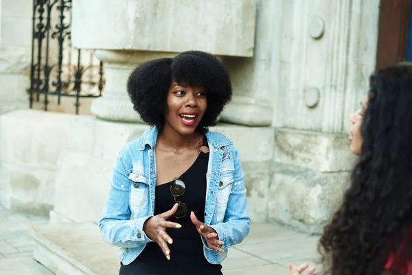 Egy afro-amerikai nő érzelmileg elmesél egy történetet a barátjának. Városi háttér. Többnemzetiségű csoport — Stock Fotó
