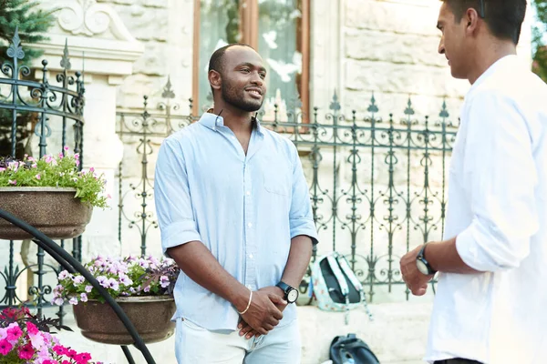 A black businessman is talking in an informal setting with a business partner on a city street — Stock Photo, Image