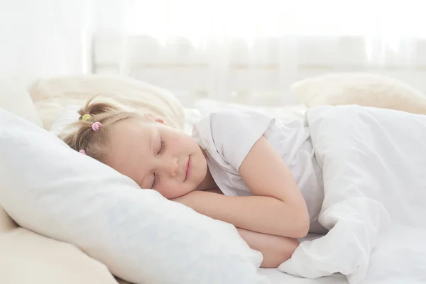 O fetiță drăguță se bucură de un pui de somn după-amiază în pat după cină — Fotografie, imagine de stoc