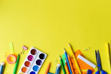 Sarı arka planda okul aksesuarları. Uzayı kopyala Okula, yaratıcı daireye geri dön.