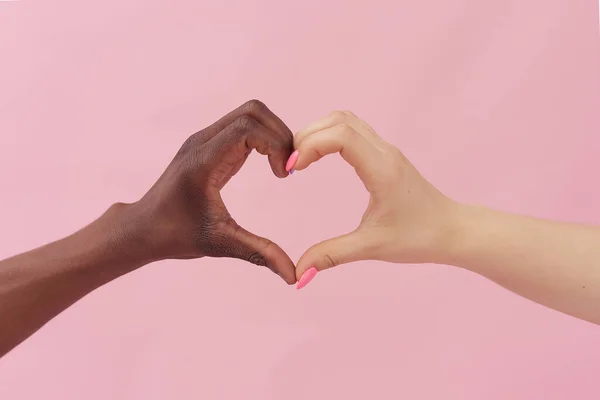 Белая женщина и афро-американец показывают свое сердце на розовом фоне. Понятие расизма, толерантности — стоковое фото