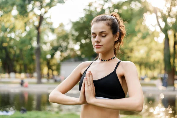 Lugn ung kvinna utövar yoga och meditation när hon står i parken. Friluftsliv — Stockfoto