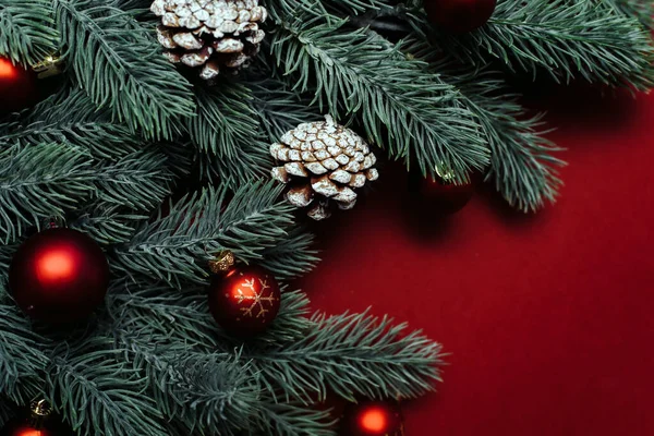 圣诞树树枝之间的文字空间，带有圣诞装饰和红色背景的球。圣诞作文。新年快乐。案文的篇幅 — 图库照片