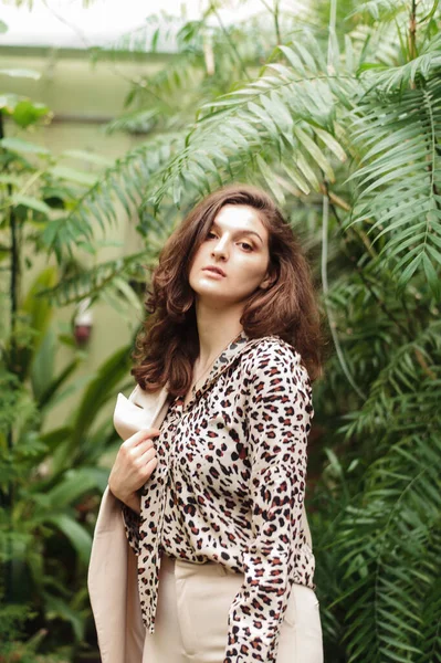 Hermosa chica bonita en una blusa de leopardo sobre un fondo de selva verde — Foto de Stock