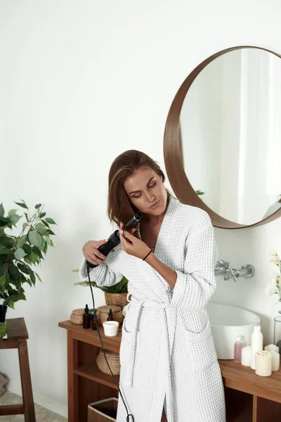 Молодая женщина вытирает волосы в ванной. Стиль красоты — стоковое фото