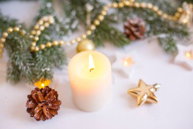 Noel arkaplanı, Altın Noel oyuncakları, boncuklar ve yanan bir mum. Noel 'le birlikte tebrik kartı