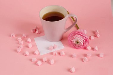 Kalp şeklinde lokum, gül ve kağıt kaplı bir fincan çay.